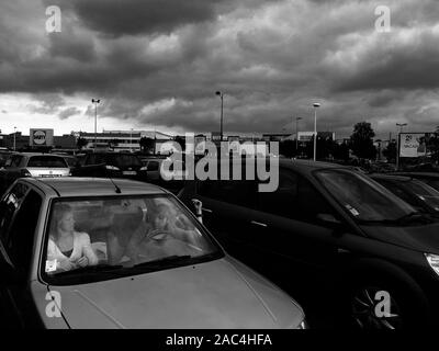 AJAXNETPHOTO. Amiens, Frankreich. - Regen Wolken - zwei Menschen, die IM GESPRÄCH IN EINEM AUTO IN EINE AUSSERHALB DER STADT GELEGENES RETAIL PARKPLATZ. Foto: Jonathan Eastland/AJAX REF: GR 121506 BW 3638 Stockfoto