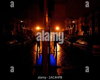 AJAXNETPHOTO. WORTHING, WEST SUSSESX, England. - NIGHT WALKER - MANN ENTLANG eine nasse Straße BEI NACHT IM REGEN SICH IM SCHAUFENSTER. Foto: Jonathan Eastland/AJAX REF: GR 80106 800 Stockfoto