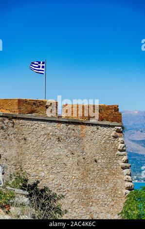 Die griechische Fahne winken über die historische Festung Palamidi gegen den tiefblauen Himmel. Stadt Nafplio, Argolis, Griechenland, Europa Stockfoto