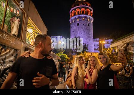 Junge Frauen, die in der Nacht in der Nähe von selfies Galata-turm, Beyoglu, Istanbul, Türkei Stockfoto