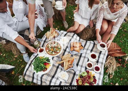 Blick von oben auf die Gruppe der Freunde der Familie haben, Abendessen im Freien mit ein paar gute Häppchen Stockfoto