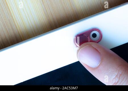 Ein Rosa Metall Kamera Privatsphäre abdecken. Schieben Sie die Webcam. Abdeckung für ein elektronisches Gerät mit einem Finger. Stockfoto