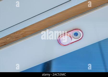 Eine rosa Farbe kamera Privatsphäre abdecken. Schieben Sie die Webcam. Abdeckung für ein elektronisches Gerät mit einer Tastatur an einem hölzernen Tisch Stockfoto