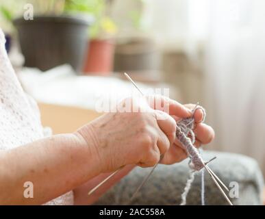 In der Nähe der Hände ist eine ältere Frau stricken Socken Stockfoto