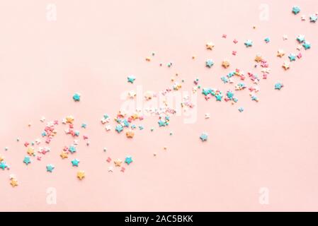 Farbenfrohen Pastelltönen Streusel auf rosa Hintergrund, Ansicht von oben, kopieren. Süße Kuchen Gebäck Zutaten, urlaub geburtstag Konzept, kreative Grenze. Stockfoto