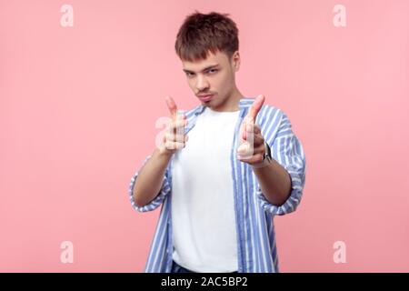 Portrait von gefährlichen braunhaarige Mann mit dem kleinen Bart und Schnurrbart in casual Striped Shirt zeigt mit Finger Pistolen, droht mit Pistole. Ich Stockfoto
