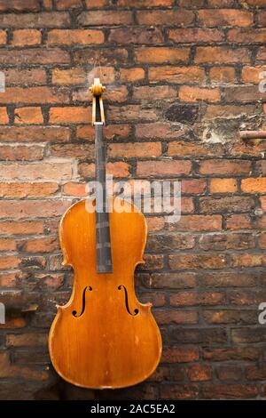 Dekoration auf der Mauer ist eine alte Geige, auf den Straßen in Liverpool Stockfoto