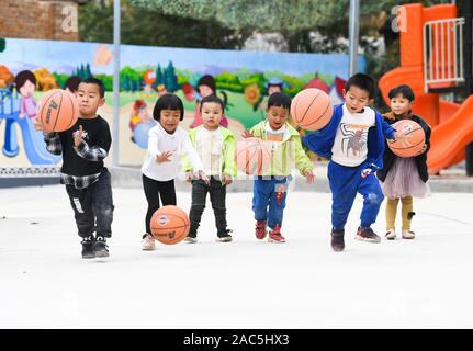 (191201) - SHILIN, Dez. 1, 2019 (Xinhua) - Schüler spielen während einer Pause in der Schule in Danuohei Dorf Guishan Township in Shilin Yi Autonomen County, im Südwesten der chinesischen Provinz Yunnan, Nov. 28, 2019. Danuohei Dorf, mit einer Geschichte von über 600 Jahren, ist eine gut geschützte alte Dorf der Yi ethnischen Kultur. Anwohner gebauten Häuser und Straßen mit Steinen, die es einzigartig macht als "Dorf". Es ist von Bergen, Flüssen und der schönen Landschaft umgeben. Das Dorf hat nun 370 Haushalte mit einer Bevölkerung von 1000, von denen 99,8 Prozent der Yi ethnischen Gruppe gehört. Stockfoto