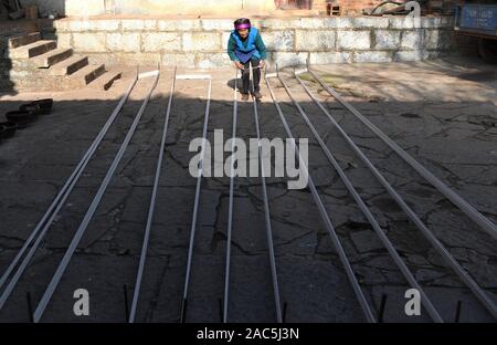 (191201) - SHILIN, Dez. 1, 2019 (Xinhua) - Bi Xiuzhen, 75, ordnet die Bettwäsche für das Weben in Danuohei Dorf Guishan Township in Shilin Yi Autonomen County, im Südwesten der chinesischen Provinz Yunnan, Nov. 28, 2019. Danuohei Dorf, mit einer Geschichte von über 600 Jahren, ist eine gut geschützte alte Dorf der Yi ethnischen Kultur. Anwohner gebauten Häuser und Straßen mit Steinen, die es einzigartig macht als "Dorf". Es ist von Bergen, Flüssen und der schönen Landschaft umgeben. Das Dorf hat nun 370 Haushalte mit einer Bevölkerung von 1000, von denen 99,8 Prozent der Yi ethnischer gro gehört Stockfoto