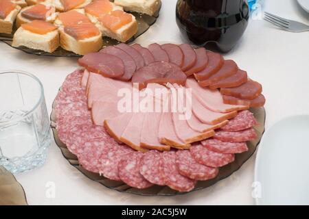 Viele Schichten der Würste von verschiedenen Sorten werden auf eine Platte gelegt Stockfoto