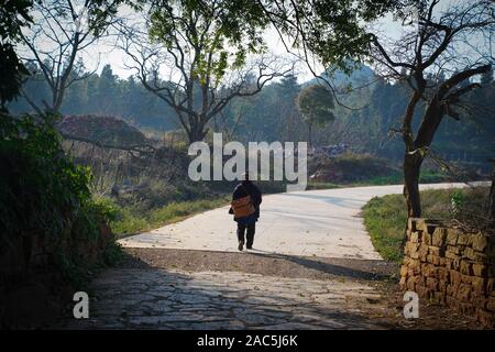 (191201) - SHILIN, Dez. 1, 2019 (Xinhua) - ein dorfbewohner Spaziergänge in Danuohei Dorf Guishan Township in Shilin Yi Autonomen County, im Südwesten der chinesischen Provinz Yunnan, Nov. 28, 2019. Danuohei Dorf, mit einer Geschichte von über 600 Jahren, ist eine gut geschützte alte Dorf der Yi ethnischen Kultur. Anwohner gebauten Häuser und Straßen mit Steinen, die es einzigartig macht als "Dorf". Es ist von Bergen, Flüssen und der schönen Landschaft umgeben. Das Dorf hat nun 370 Haushalte mit einer Bevölkerung von 1000, von denen 99,8 Prozent der Yi ethnischen Gruppe gehört. In den letzten Jahren die Stockfoto