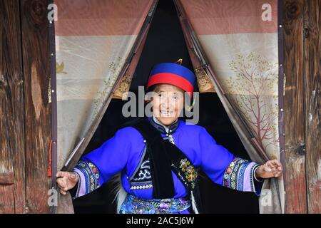 (191201) - SHILIN, Dez. 1, 2019 (Xinhua) - Wang Guangying, 65, geht aus ihrem Haus in Danuohei Dorf Guishan Township in Shilin Yi Autonomen County, im Südwesten der chinesischen Provinz Yunnan, Nov. 28, 2019. Danuohei Dorf, mit einer Geschichte von über 600 Jahren, ist eine gut geschützte alte Dorf der Yi ethnischen Kultur. Anwohner gebauten Häuser und Straßen mit Steinen, die es einzigartig macht als "Dorf". Es ist von Bergen, Flüssen und der schönen Landschaft umgeben. Das Dorf hat nun 370 Haushalte mit einer Bevölkerung von 1000, von denen 99,8 Prozent der Yi ethnischer gro gehört Stockfoto