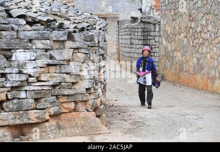 (191201) - SHILIN, Dez. 1, 2019 (Xinhua) - Er Lanxiang, 69, geht wieder nach Hause nach Einkaufen in Danuohei Dorf Guishan Township in Shilin Yi Autonomen County, im Südwesten der chinesischen Provinz Yunnan, Nov. 28, 2019. Danuohei Dorf, mit einer Geschichte von über 600 Jahren, ist eine gut geschützte alte Dorf der Yi ethnischen Kultur. Anwohner gebauten Häuser und Straßen mit Steinen, die es einzigartig macht als "Dorf". Es ist von Bergen, Flüssen und der schönen Landschaft umgeben. Das Dorf hat nun 370 Haushalte mit einer Bevölkerung von 1000, von denen 99,8 Prozent gehört zu den Yi athnis Stockfoto