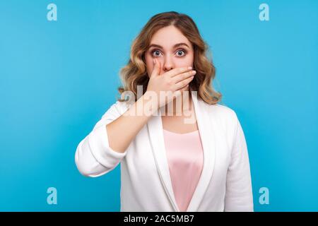 Erklären Sie nicht! Portrait von verängstigte Frau mit gewelltes Haar in weisse Jacke für den Mund mit der Hand erschrocken zu sprechen, Geheimnis, geschockt worr Stockfoto