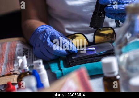 Polizei Spezialist untersucht Wallet DNA in einem Tatort zu sortieren, konzeptionelle Bild Stockfoto