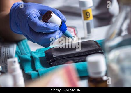 Polizei Spezialist untersucht Wallet DNA in einem Tatort zu sortieren, konzeptionelle Bild Stockfoto