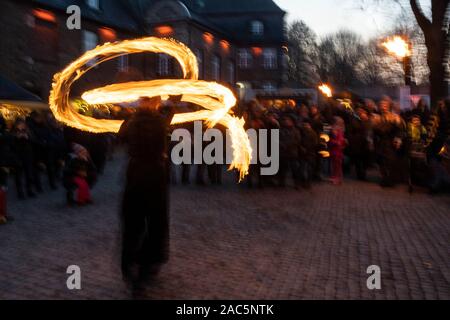 Feuershow, durchgeführt vom Wahnsinn Firedance. Im mittelalterlichen Stil Broicher Schlossweihnacht Weihnachtsmarkt öffnet sich für die ersten drei Adventswochenende auf dem Gelände von Schloss Broich in Mülheim an der Ruhr, Deutschland Stockfoto