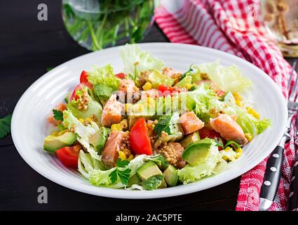 Salat mit gegrilltem Lachs, Salat, Avocado, Tomaten und Mais auf einer weißen Schüssel. Paleo Diät. Stockfoto