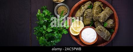 Dolma. Gefüllte Weinblätter mit Reis und Fleisch auf dunklen Tisch. Nahöstlichen Küche. Ansicht von oben, Overhead, Banner Stockfoto