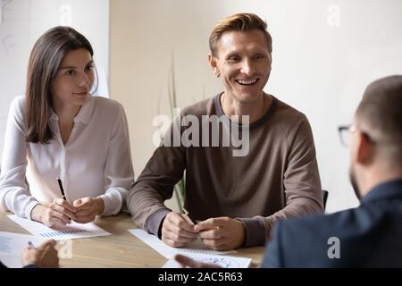 Lächelnd Mannschaftskameraden diskutieren Projekt mit Client im Büro. Stockfoto