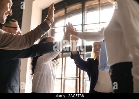 Überglücklich, älteren und jüngeren Teamkollegen Hand in Hand in der Luft. Stockfoto
