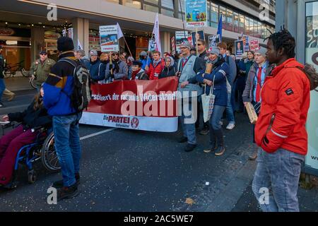 Braunschwig, Deutschland, 30. November, 2019: Protest gegen die AFD Parteitag der linken Gruppe wird durch einen Rollstuhl fahrer geführt und durch eine farbige beobachtete Stockfoto