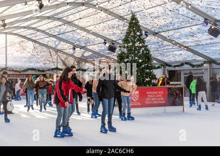 Leute Eislaufen auf der Eisbahn in Winchester Innenstadt während der Weihnachtszeit, Hampshire, Großbritannien Stockfoto