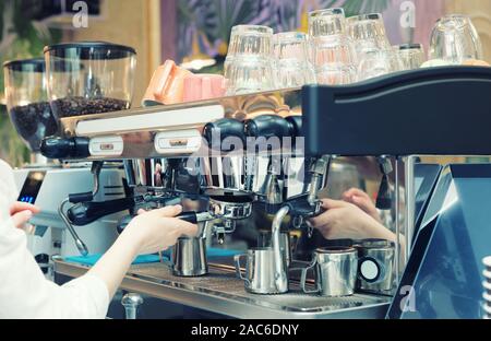 Barista ist die Zubereitung von Kaffee in einem Restaurant mit professionellen Espressomaschine, getönten Bild Stockfoto