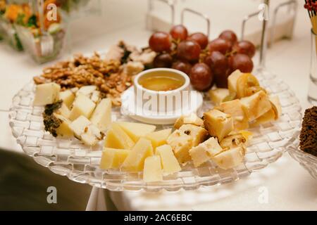 Käseplatte mit Nüssen und Trauben auf Tafel, getönten Bild Stockfoto