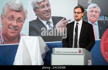 Wiesbaden, Deutschland. 01 Dez, 2019. Jan-Hendrik Lübcke, Sohn von Walter Lübcke, spricht nach der Preisverleihung. Im Hintergrund kann man tolle Portraits von Walter Lübcke. Die Wilhelm Leuschner Medaille 2019 wird posthum an Walter Lübcke (CDU), ehemaliger Präsident des Kasseler Regierung, die im Juni erschossen wurde ausgezeichnet. Credit: Andreas Arnold/dpa - ACHTUNG: Verwenden Sie nur im vollständigen Format/dpa/Alamy leben Nachrichten Stockfoto