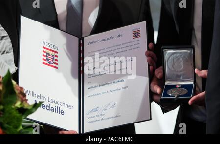 Wiesbaden, Deutschland. 01 Dez, 2019. Christoph und Jan-Hendrik Lübcke (L-R), die Söhne von Walter Lübcke, halten Sie das Zertifikat und die Medaille nach der Preisverleihung. Die Wilhelm Leuschner Medaille 2019 wird posthum an Walter Lübcke (CDU), ehemaliger Präsident des Kasseler Regierung, die im Juni erschossen wurde ausgezeichnet. Credit: Andreas Arnold/dpa/Alamy leben Nachrichten Stockfoto