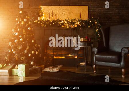 Schönen Urlaub eingerichtete Zimmer mit Weihnachtsbaum mit Geschenken darunter. Schönen Kamin, Kerzen, Leuchten und Stuhl im Zimmer Stockfoto