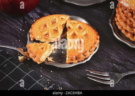 Ut öffnen Cookie mit Apfelmus in Form von tarte Kuchen gefüllt auf Eisen Fach mit Stück auf Gabel auf dunklem Hintergrund Stockfoto