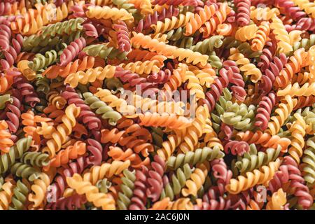 Ungekocht tricolore Fusilli twist Formen Hintergrund. Foto pasta twist Formen. Stockfoto