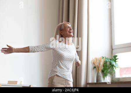 Sorglos lebendige ältere Frau streckte die Hände fühlt sich glücklich und gesund Stockfoto