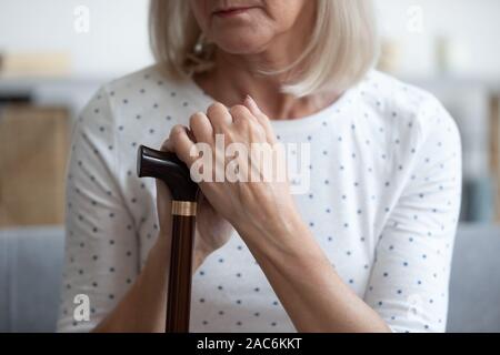 Detailansicht Zuckerrohr und Arme der niedergedrückten deaktiviert pensionierte Frau Stockfoto