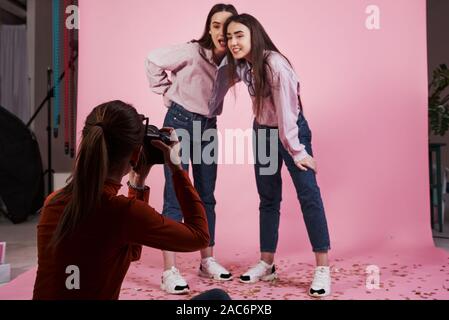 Von unten. Bild von zwei Mädchen, die von den weiblichen Kameramann im Studio fotografiert. Stockfoto