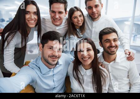 Foto aus dem Telefon. Jungen Team, selfie in der klassischen Kleidung in der modernen gut beleuchtete Büro Stockfoto