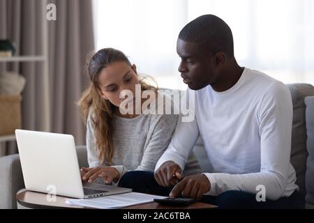 Tausendjährige gemischtrassiges Ehepaar Berechnung der monatlichen Budget. Stockfoto