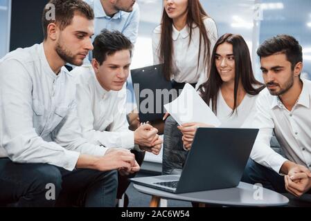 Gemeinsam in freundlicher Atmosphäre mit Laptop auf dem Tisch befindet. Stockfoto