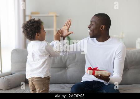 Gerne afrikanische ameican Mann, High Five zum Sohn aufgeregt. Stockfoto