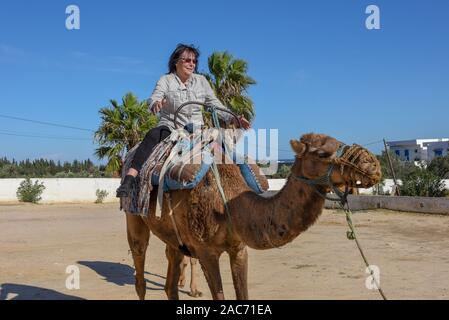 Sousse, Tunesien - 8 November 2019: Tourist auf einer Kamelkarawane in Sousse in Tunesien Stockfoto