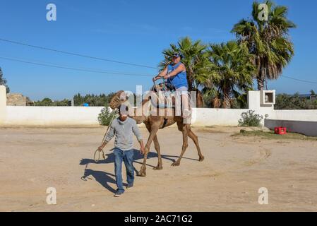 Sousse, Tunesien - 8 November 2019: Tourist auf einer Kamelkarawane in Sousse in Tunesien Stockfoto