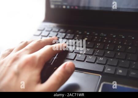 Nahaufnahme von männlichen Händen tippen auf Laptoptastatur Stockfoto
