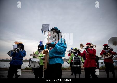 Krefeld, Deutschland. 01 Dez, 2019. "Zwarten Piets "Willkommen das Publikum und Musik machen. Der Sinterklaas (Nicholas) von Venlo kommt mit mehreren "Zwarten Piets" (Schwarzer Peter) im Zuge am Steiger in Krefeld mit dem Boot. Traditionell wird der "Zwarten Piets" Süßigkeiten an die Kinder verteilen. In den Niederlanden, der schwarz lackierte Helfer des Sinterklaas sind heute umstritten. Credit: Fabian Strauch/dpa/Alamy leben Nachrichten Stockfoto