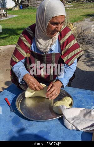 Sousse, Tunesien - 8 November 2019: Alte Dame Backen ein traditionelles arabisches Brot in Sousse in Tunesien Stockfoto