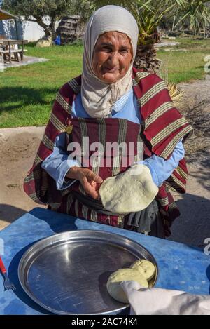 Sousse, Tunesien - 8 November 2019: Alte Dame Backen ein traditionelles arabisches Brot in Sousse in Tunesien Stockfoto