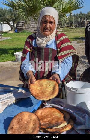 Sousse, Tunesien - 8 November 2019: Alte Dame Backen ein traditionelles arabisches Brot in Sousse in Tunesien Stockfoto