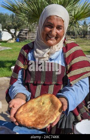 Sousse, Tunesien - 8 November 2019: Alte Dame Backen ein traditionelles arabisches Brot in Sousse in Tunesien Stockfoto