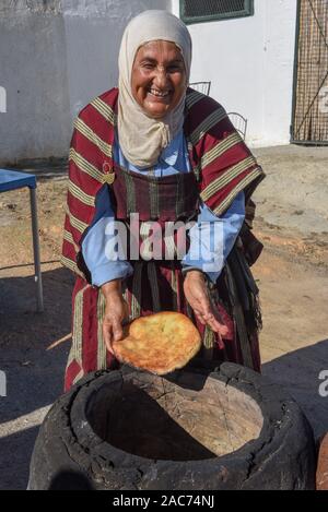 Sousse, Tunesien - 8 November 2019: Alte Dame Backen ein traditionelles arabisches Brot in Sousse in Tunesien Stockfoto